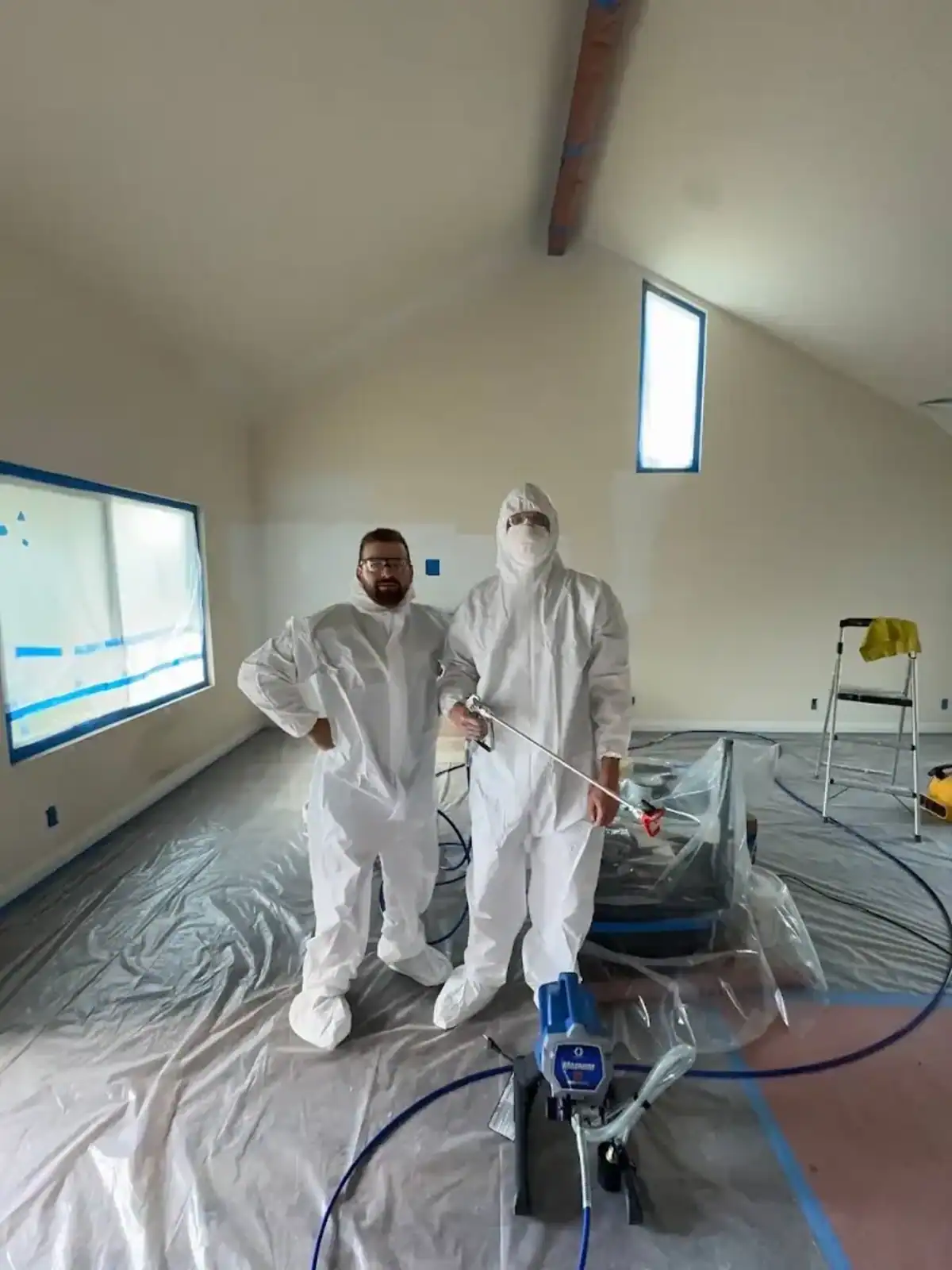 Construction workers in protective suits working on interior renovation.