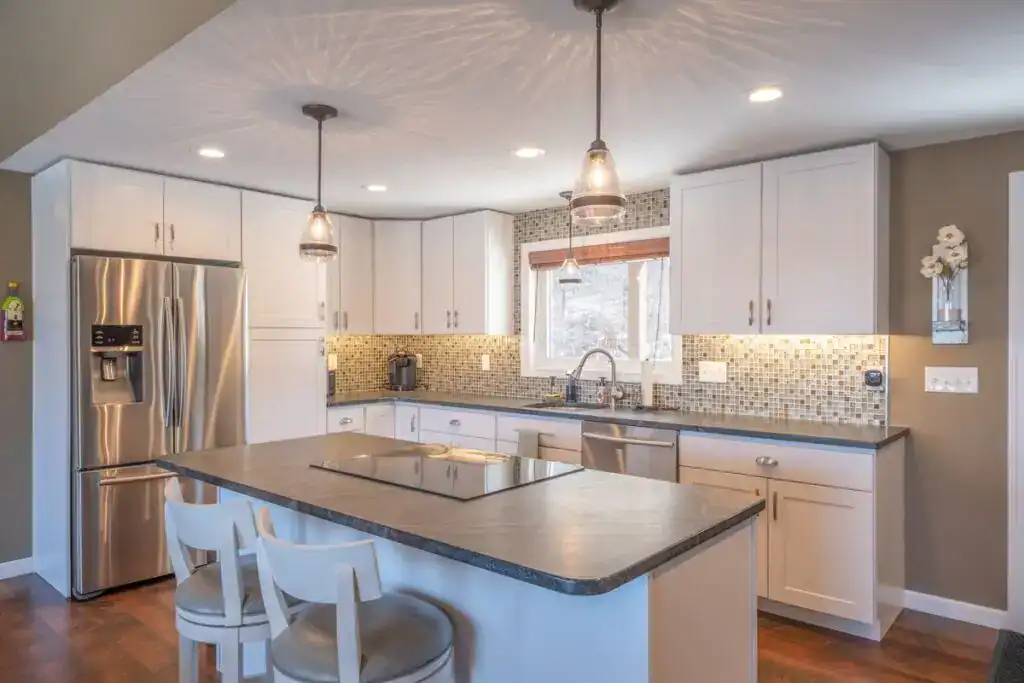 Contemporary kitchen with white cabinets, granite countertops, and stainless steel appliances.