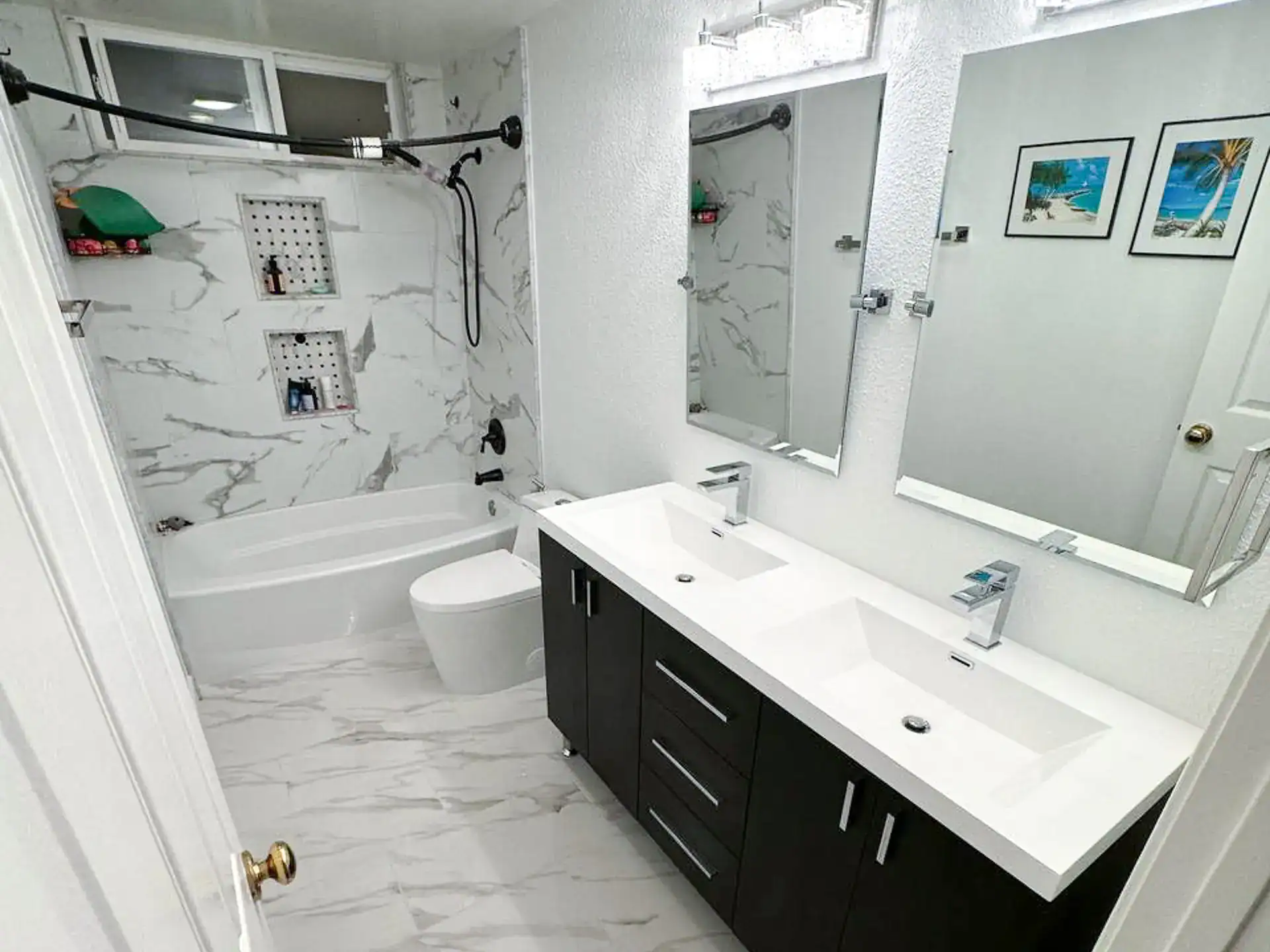 Contemporary bathroom with marble tiles, dual sinks, and walk-in shower.
