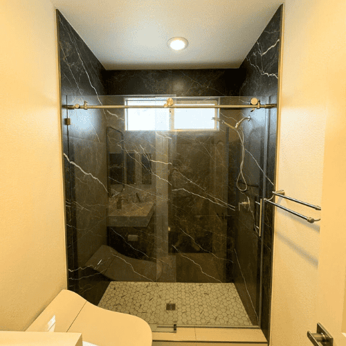 Elegant black marble shower with sleek design and natural veining. Perfect for Irvine bathroom renov.
