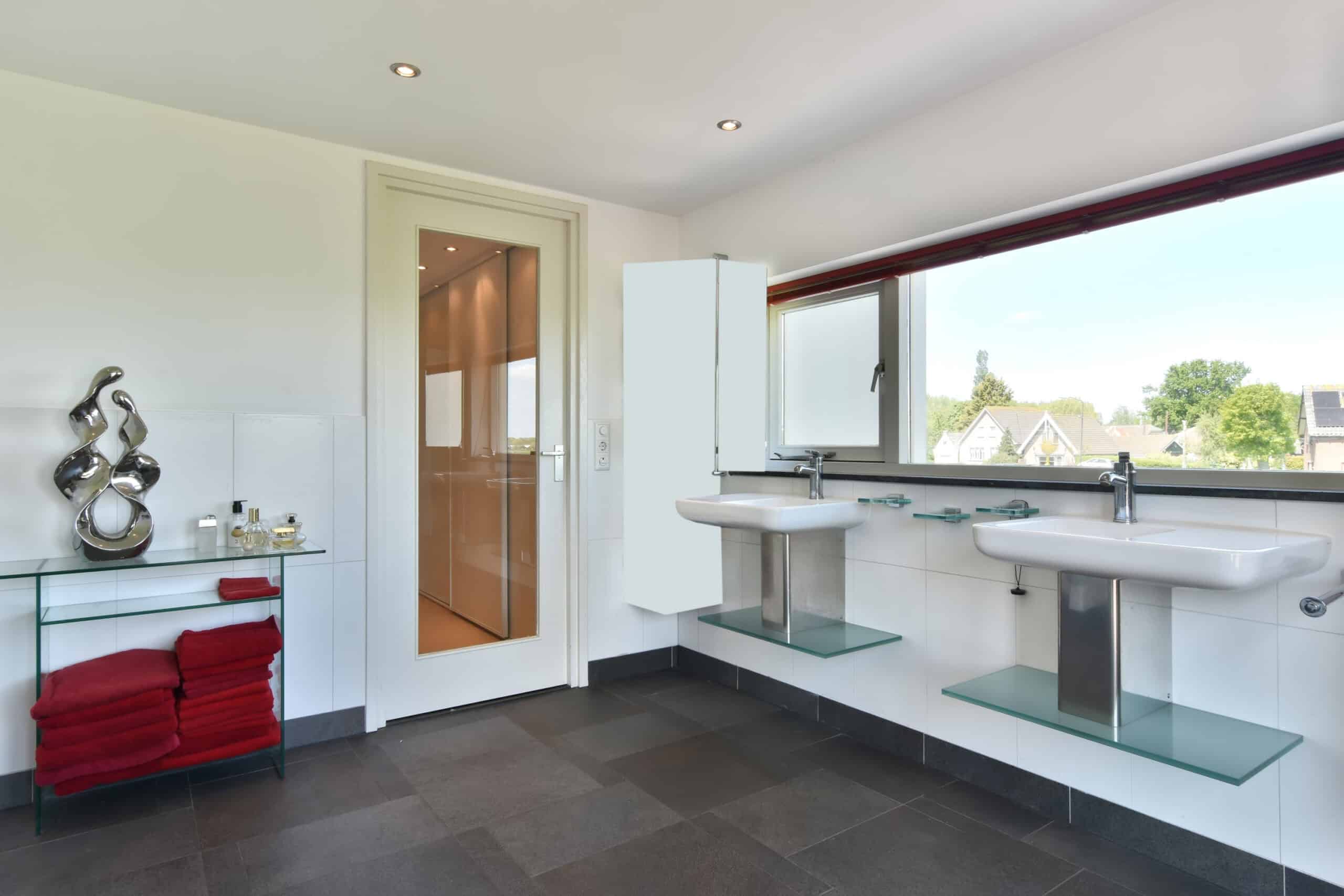 Bathroom with dual sinks, large window, and scenic Newport Beach view.