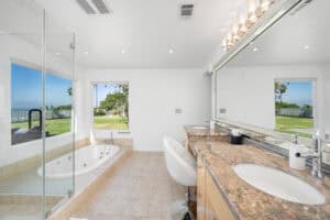 Modern master bathroom with a large soaking tub and ocean view in Orange County homes.