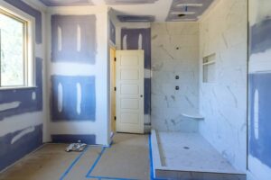 Modern bathroom under construction with marble walls and new fixtures.