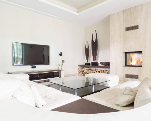 Elegant living room featuring a wall-mounted TV, cozy fireplace, and contemporary decor. Perfect for.